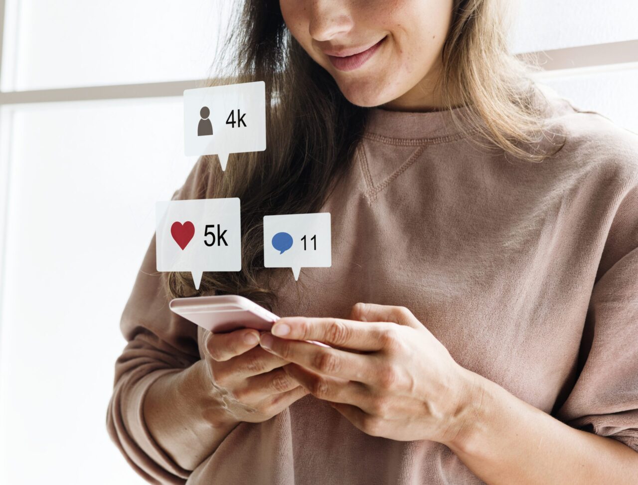 mulher usando o celular para divulgar sua empresa nas redes sociais através do marketing de conteúdo
