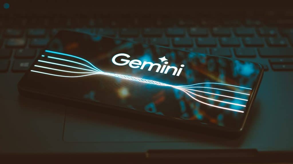 Celular com logotipo do Gemini colocado sobre teclado de notebook